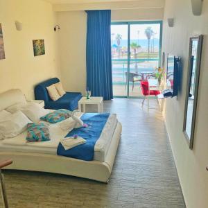 a bedroom with a bed and a living room at Sur La Mer Hotel Ashdod in Ashdod