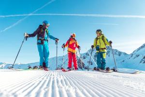 3 Menschen auf Skiern im Schnee auf einem Berg in der Unterkunft Frühstückspension Türtscher in Galtür