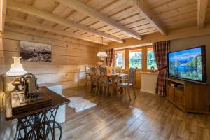 a living room with a dining room table and a television at Aparthotel Bambi in Zakopane