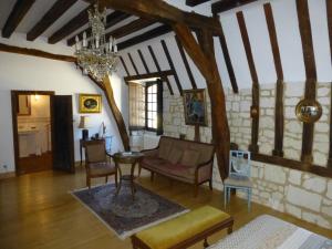 a living room with a table and chairs in a building at Le Clos Chavigny in Lerné