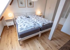uma cama num pequeno quarto com piso em madeira em Ferienloft in der blauen Scheune em Binzen