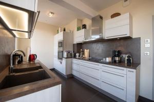 a kitchen with white cabinets and a sink at Le 360 TOUR PERRET 19eme PANORAMA 4 ETOILES in Amiens