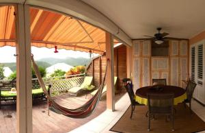 a porch with a hammock and a table and chairs at Les Balisiers in Les Anses-dʼArlets