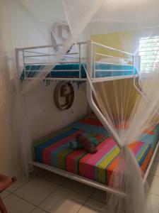 ein Schlafzimmer mit einem Etagenbett mit einer bunten Decke in der Unterkunft Les Balisiers in Les Anses-dʼArlets