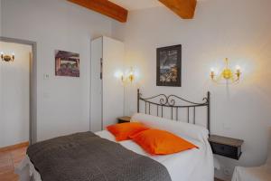 - une chambre avec un lit et des oreillers orange dans l'établissement coustelline, au Lavandou