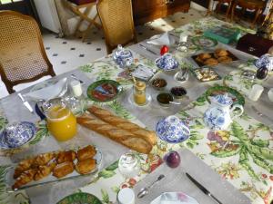 una mesa con un mantel con alimentos para el desayuno en Le Clos Chavigny, en Lerné