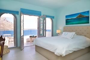 a bedroom with a bed and a view of the ocean at MasouriBlu Boutique Hotel in Masouri