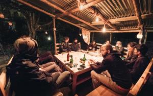a group of people sitting around a table at Orchards House - The Hidden Tribe in Manāli