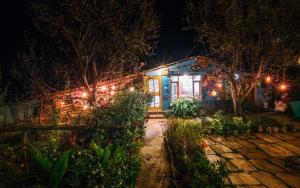 ein nachts beleuchtetes Haus mit Licht in der Unterkunft Orchards House - The Hidden Tribe in Manali