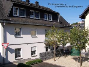 une maison blanche avec un toit noir dans l'établissement Sommerwind am Kurgarten, à Willingen