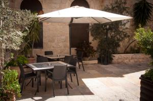 stół i krzesła z parasolem na patio w obiekcie Gloria Hotel w Jerozolimie