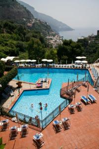 una grande piscina con sedie e persone di Hotel Royal Positano a Positano