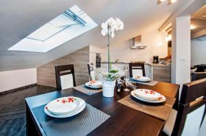 a dining room with a wooden table with red flowers on it at Apartments Centener in Rovinj