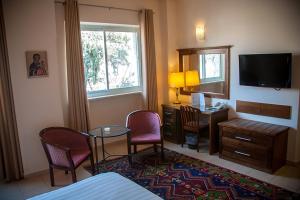 a hotel room with a table and chairs and a television at Gloria Hotel in Jerusalem