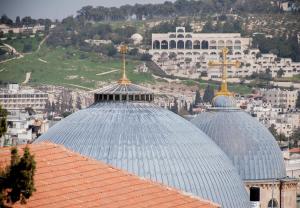 two domes with gold crosses on top of a building at Gloria Hotel in Jerusalem
