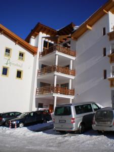 a building with cars parked in a parking lot at Haus König in Obergurgl