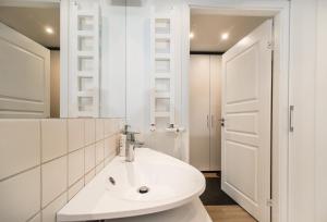 ein weißes Badezimmer mit einem Waschbecken und einem Spiegel in der Unterkunft Vilnius City Centre apartment in Vilnius