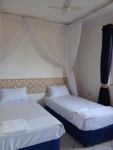 two beds sitting next to each other in a room at Royal Palms Apartment A4 in Mombasa +21 photos