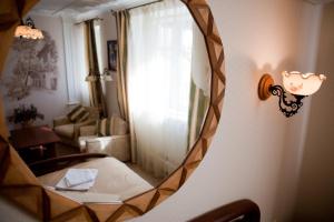 espejo que refleja una habitación con silla y ventana en Villa Oselya en Kiev