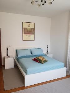 a white bedroom with a bed with blue sheets at Angela di Venezia House in Venice