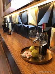 a plate of fruit and wine glasses on a counter at Top Designed Apartments in Gdańsk
