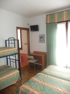 a bedroom with two bunk beds and a desk at Hotel Da Bepi in Lido di Jesolo