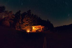 Una casa iluminada en un campo por la noche en Maringotka ticha, en Dvůr Králové nad Labem