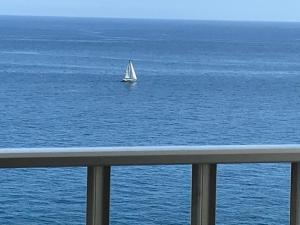 a sail boat in the water with a balcony at Apartamentos do Mar Funchal in Funchal