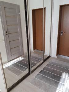 ein verspiegeltes Zimmer mit zwei Türen und zwei Spiegeln in der Unterkunft Apartamentai Vilniaus Street in Šiauliai
