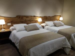 duas camas num quarto de hotel com duas lâmpadas em Hotel Rural El Yunque em Tarilonte