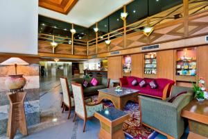 eine Lobby eines Hotels mit einer roten Couch und Tischen in der Unterkunft Charoen Hotel in Udon Thani