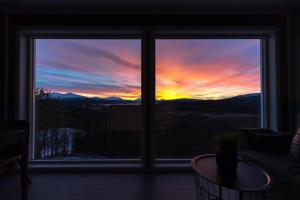 a view of a sunset from a window at Aurora Borealis Observatory in Silsand
