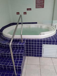 a blue tiled bathroom with a bath tub with blue tiles at Estrela do Mar in Florianópolis