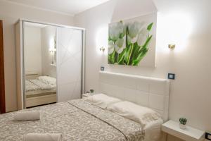 バールにあるApartment Stefanoの鏡とベッドのある白い寝室