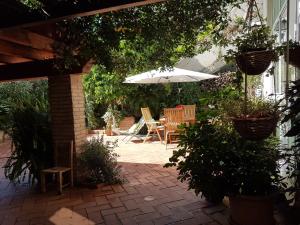 a patio with a table and an umbrella and chairs at Marco's house in Dolianova