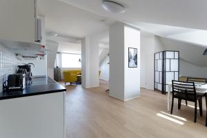 a kitchen and living room with a table and chairs at Forenom Serviced Apartments Helsinki Kruununhaka in Helsinki