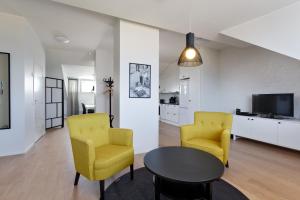 a living room with two yellow chairs and a table at Forenom Serviced Apartments Helsinki Kruununhaka in Helsinki