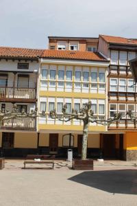 un edificio giallo con un albero di fronte di Crisol Plaza ad Ampuero