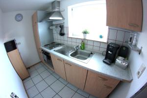 una pequeña cocina con fregadero y ventana en Ruhige und gemütliche Ferienwohnung in Calden en Calden