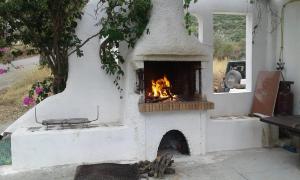 an outdoor oven with a fire in it at Window To The Aegean in Velanídhia