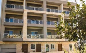 an apartment building with balconies and tables at Marsaskala Penthouse Apartment in Marsaskala