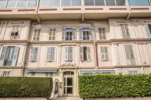 un grand bâtiment rose avec des fenêtres et une porte dans l'établissement Le BLUMARINE, à Cannes