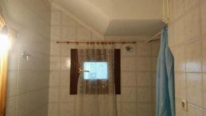 a shower with a shower curtain in a bathroom at Window To The Aegean in Velanídhia