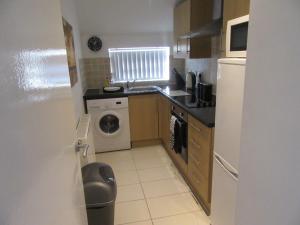 a small kitchen with a washing machine and a washer at No 6 AT 19 IVANHOE - LARGE 2 BED NEAR SEFTON PARK AND LARK LANE in Liverpool
