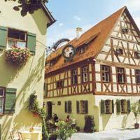 Un edificio con un orologio sopra. di Hotel Weisses Ross a Dinkelsbühl