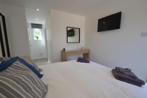 a bedroom with a white bed with two towels on it at Alberts Dairy Cottage in East Cowes