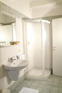 a white bathroom with a shower and a sink at Hotel La Pace in Pontedera +67 photos