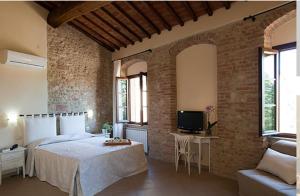 a bedroom with a large bed and a tv in it at Arnolfo B&B in Colle Val D'Elsa