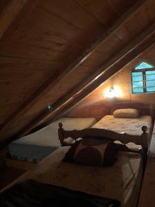 two twin beds in a attic with a window at Cabaña de montaña La Magnolia, Cerro de la Muerte De La Cañuela Cloud Forest in Tres de Junio