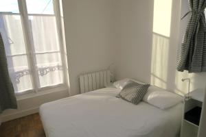 カブールにあるappartement dans villa cabourgeaiseの窓付きの客室の白いベッド1台